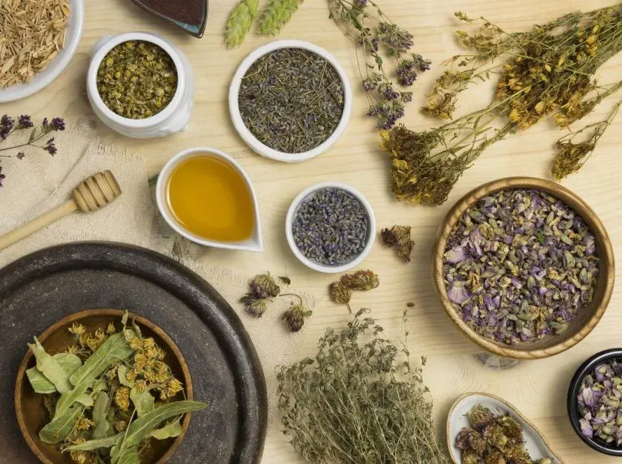 Gedroogde kruiden, lavendel en een schaaltje olie op een houten tafel